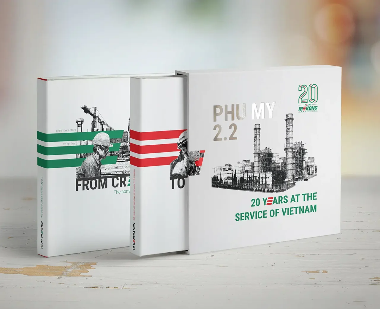 Tre libri commemorativi sulla centrale elettrica Phu My 2.2, che celebrano i 20 anni di Mekong Energy, con copertine dal design industriale.